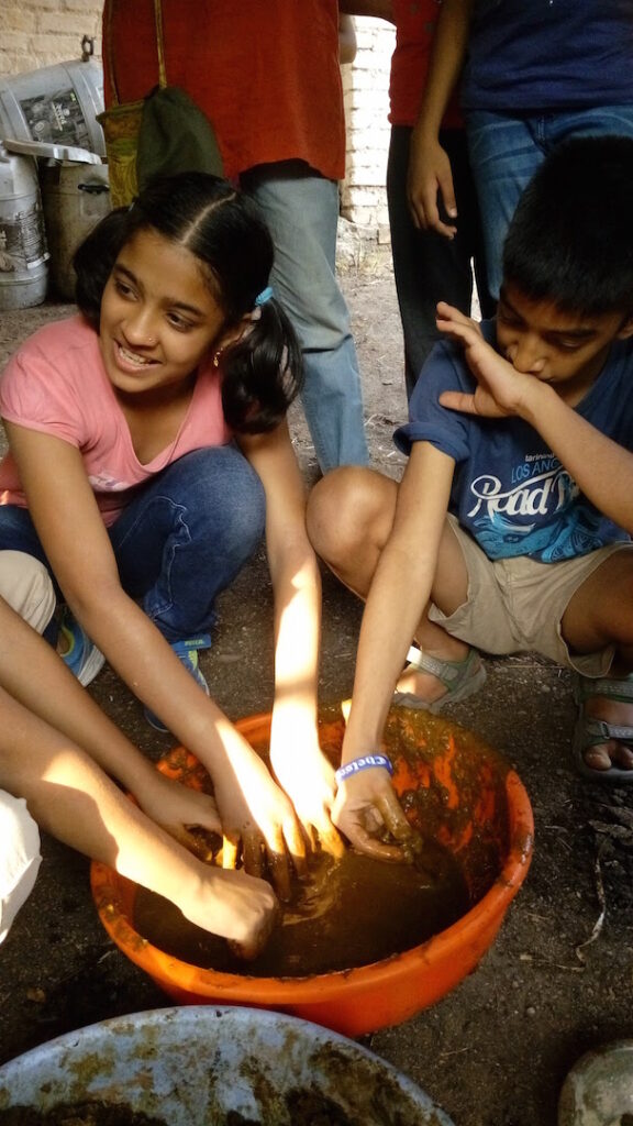 Children mixing cow dung to make manure
